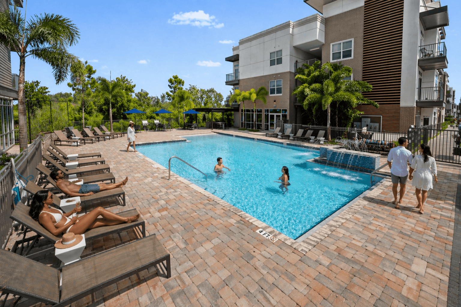 A swimming pool with people relaxing and swimming in it.